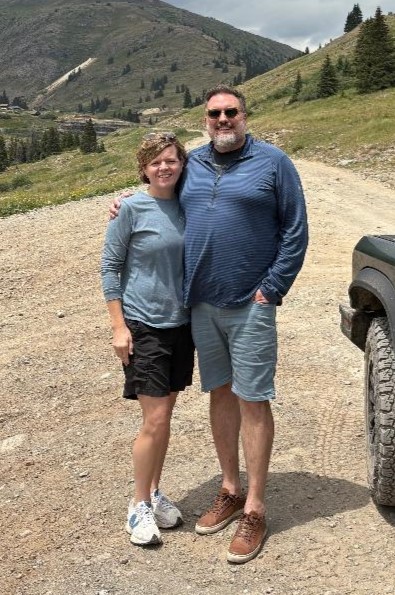 Photo of FOL Board Member Amy Tokarz standing on a dirt road on a mountain pass.