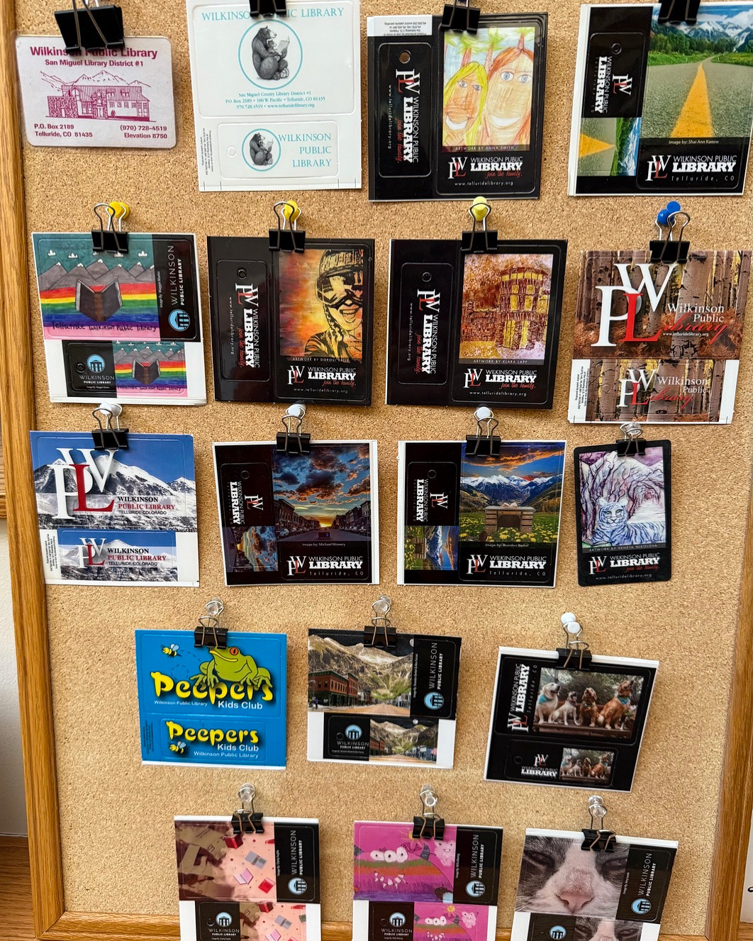 11 different WPL library card designs pinned to a cork board